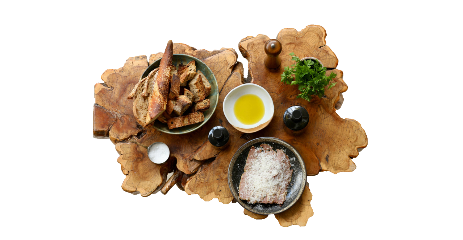 A Sicilian table — sourdough, sea salt, grated cheese, herbs and Castruriali olive oil on a live-edge board